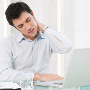 Businessman with neck pain after long hours at work